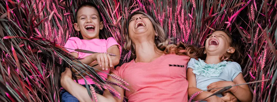 Kinder und Mutter lachend im Kornfeld